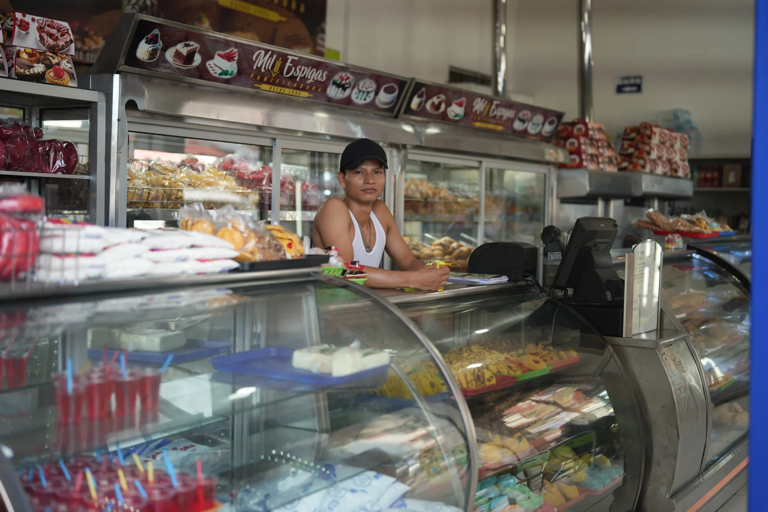 hombre adulto atendiendo la caja de una panaderia