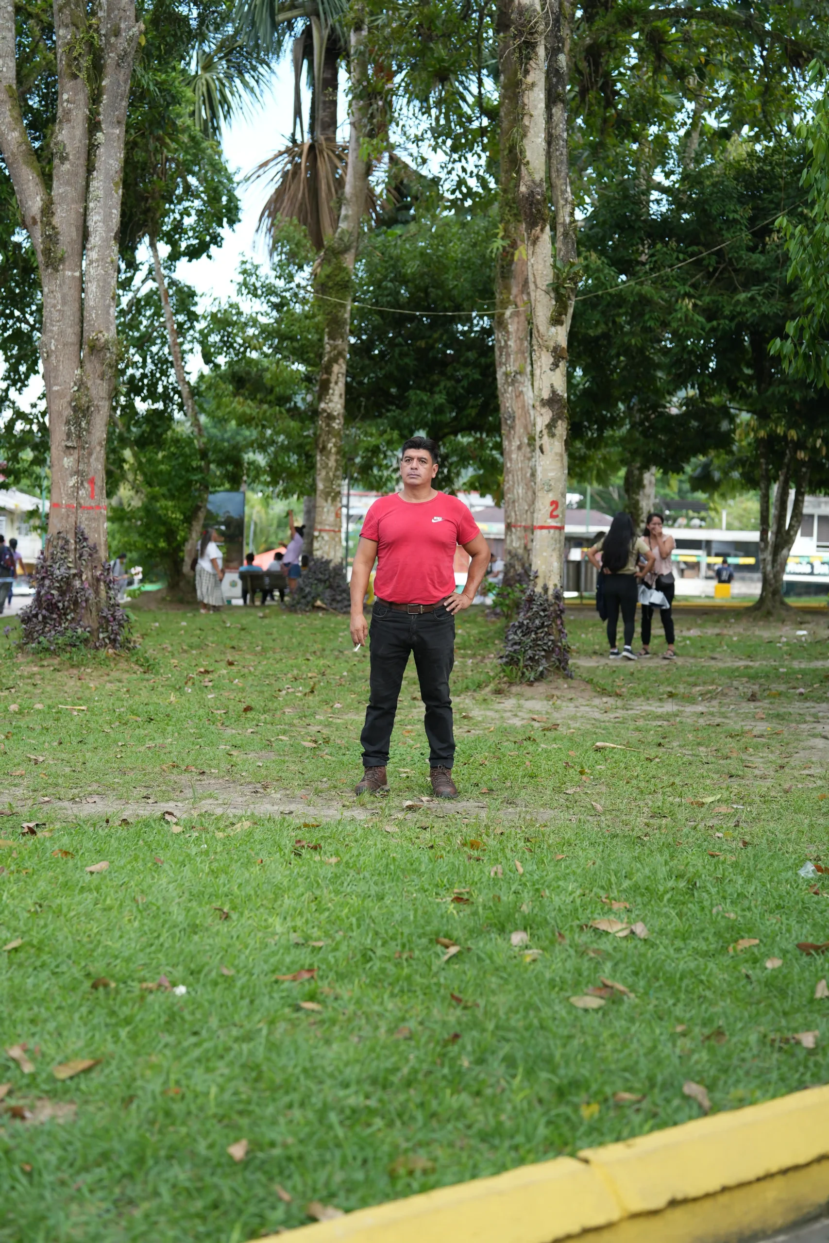 adulto con camiseta roja en medio de un parque