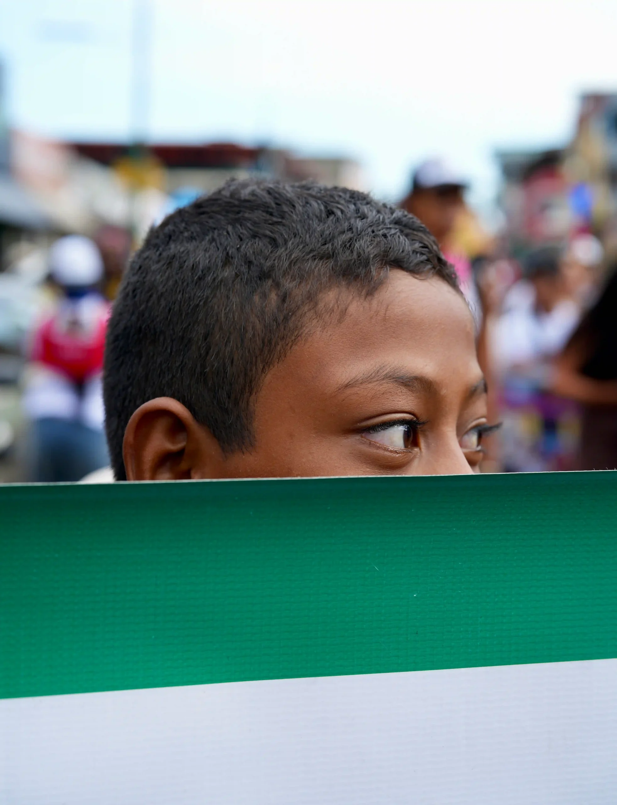 niño sosteniendo una bandera verde y blanca